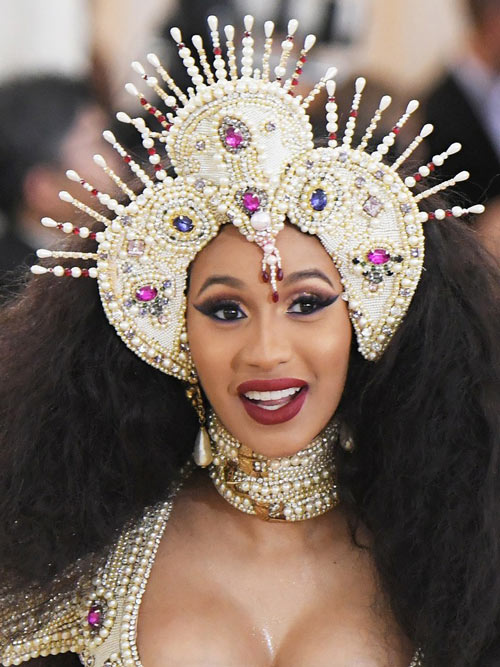 Cardi B portait un chapeau de tri-point couvert de perles, de strass et de bijoux et le maquillage rose-oeil fumé